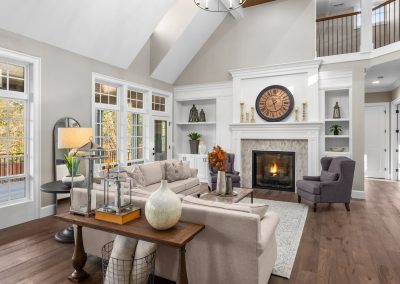 living room with vaulted ceilings, beige couches and fireplace
